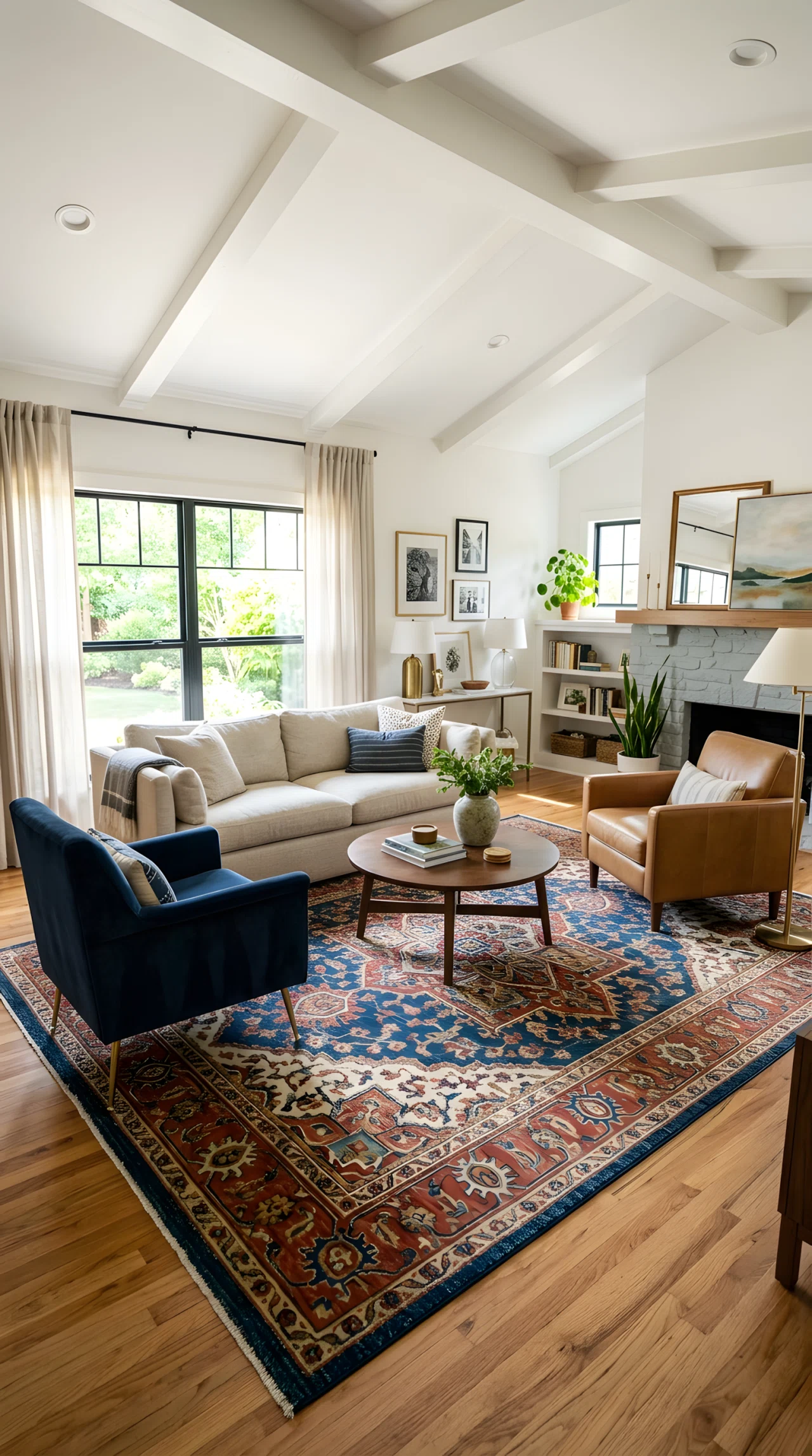 Wide-angle photograph of a living room with a large patterned wool area rug under a full seating arrangement of sofa and two armchairs, all furniture legs resting on the rug, bright natural light, vibrant rug pattern colors, photorealistic interior photography, full room visible from a slightly elevated angle.